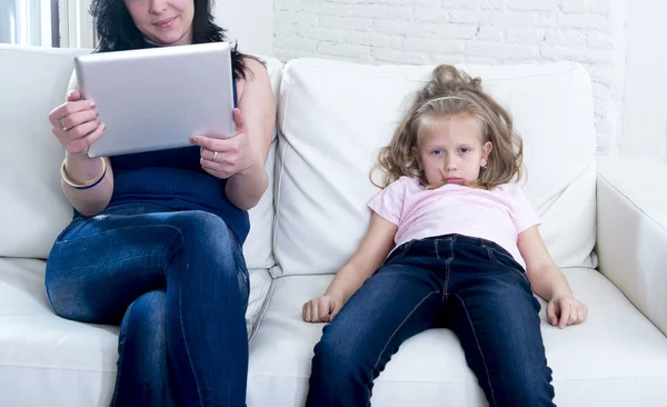 Internet network addict mother using digital tablet pad ignoring little sad daughter left alone bored — Stock Photo, Image