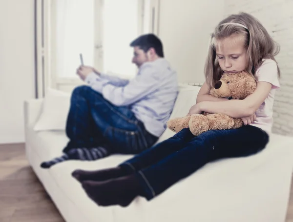 Internet addict father using mobile phone ignoring little sad daughter bored hugging teddy bear — Stock Photo, Image