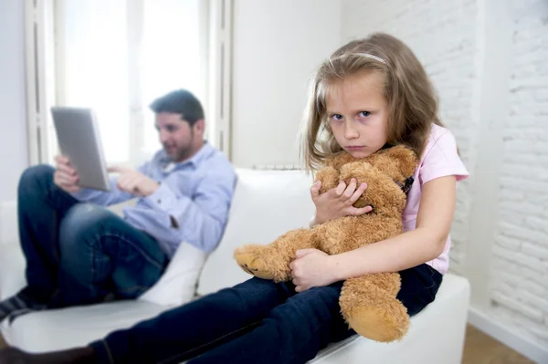 Adicto a internet padre usando tableta digital haciendo caso omiso de la pequeña hija triste aburrido abrazo osito de peluche — Foto de Stock