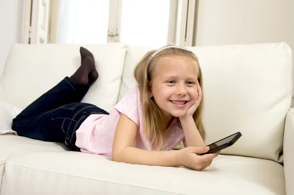 Menina loira feliz em casa sofá usando o aplicativo de internet no telefone móvel — Fotografia de Stock