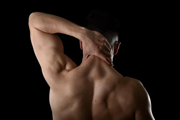Joven musculoso hombre deportivo sosteniendo dolor de cuello masajeando zona cervical sufriendo dolor corporal —  Fotos de Stock