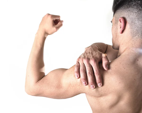 Молодий м'язовий спортсмен тримає біль у плечі, торкаючись до болю, масажуючи в стресі тренування — стокове фото
