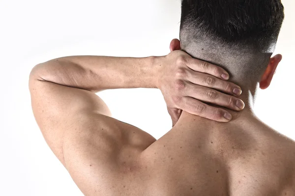 young muscular sport man holding sore neck massaging cervical area suffering body pain