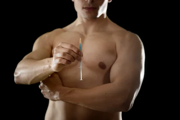 Young athletic sportsman holding syringe in sport doping and cheat concept — Stock Photo, Image