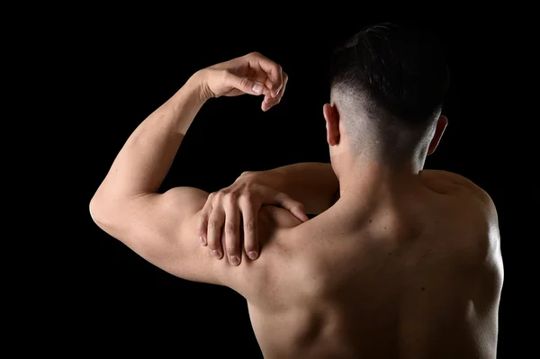 Jovem homem esporte muscular segurando ombro dolorido na dor tocando massagem no estresse treino — Fotografia de Stock