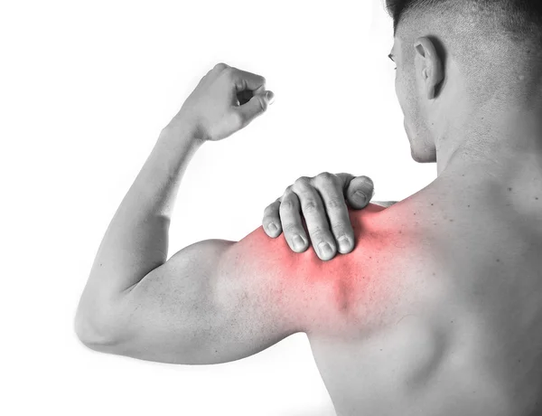 Young muscular sport man holding sore shoulder in pain touching massaging in workout stress — Stock fotografie