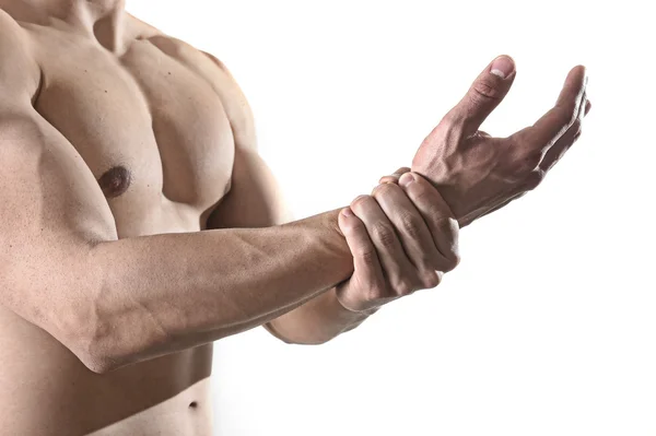 Молодий чоловік з сильним м'язовим тілом, що тримає пошкоджений зап'ясток, страждає від болю в спортивній травмі — стокове фото