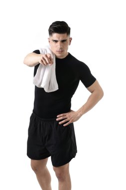 young attractive sport man with fit strong body giving holding towel on his shoulder pointing finger