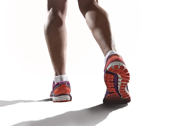 Nära håll fötter med löparskor och kvinnliga starka atletiska ben av sport kvinna jogging — Stockfoto