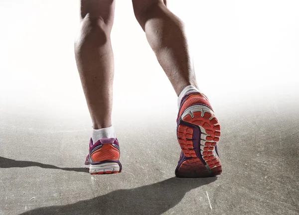 Cerrar los pies con zapatos de correr y piernas atléticas fuertes femeninas de la mujer del deporte corriendo — Foto de Stock