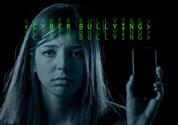 worried teenager holding mobile phone as internet cyber bullying