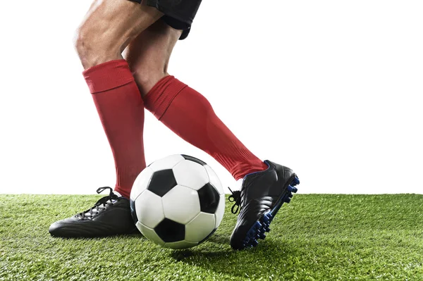 Jogador de futebol em meias vermelhas e sapatos pretos correndo e driblando com a bola jogando na grama — Fotografia de Stock