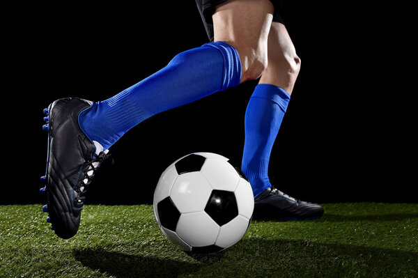  ноги и ноги футболиста в действии бег и дриблинг с мячом играет на зеленой траве
