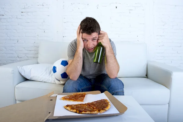 Mann mit Ball-Pizza und Bierflasche schaut Fußballspiel im Fernsehen und bedeckt Augen traurig und enttäuscht über Misserfolg oder Niederlage — Stockfoto