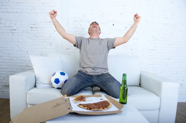 Uomo che celebra l'obiettivo a casa divano guardando la partita di calcio in televisione — Foto Stock