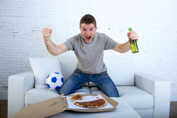 Homem celebrando gol em casa sofá assistindo jogo de futebol na televisão — Fotografia de Stock