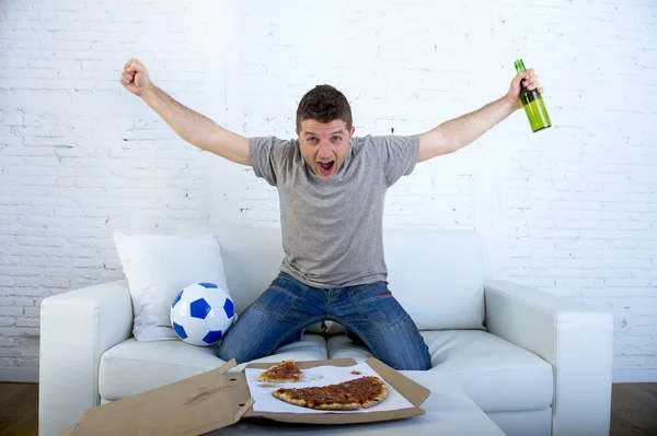 Homem celebrando gol em casa sofá assistindo jogo de futebol na televisão — Fotografia de Stock