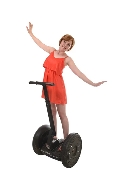 Young attractive tourist woman in chic summer dress smiling happy hands free riding electrical segway — Zdjęcie stockowe