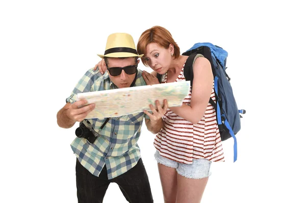 Young tourist couple reading city map looking lost and confused loosing orientation with girl carrying travel backpack — Stok fotoğraf