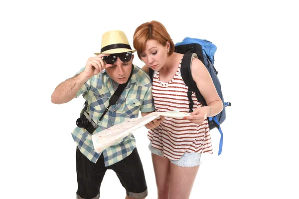 Young tourist couple reading city map looking lost and confused loosing orientation with girl carrying travel backpack — Stock Fotó