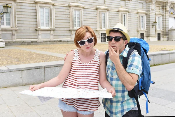 Jeune couple de touristes visitant l'Europe lire la carte de la ville à la recherche perdu et confus perdre l'orientation — Photo