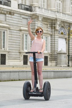 young attractive tourist woman in shorts city tour riding happy electrical segway in Spain