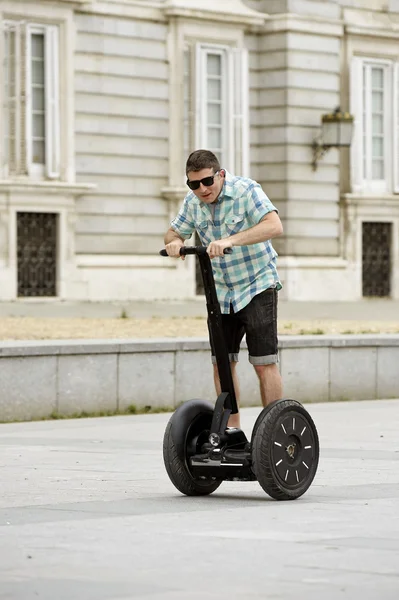 Young happy tourist man riding city tour segway driving happy and excited visiting Madrid palace — стокове фото