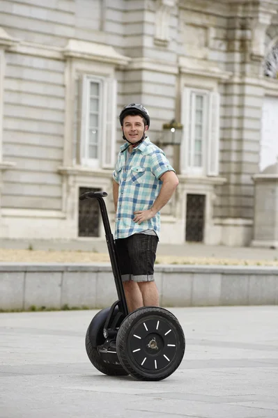 Young happy tourist man wearing safety helmet headgear riding city tour segway driving happy — ストック写真