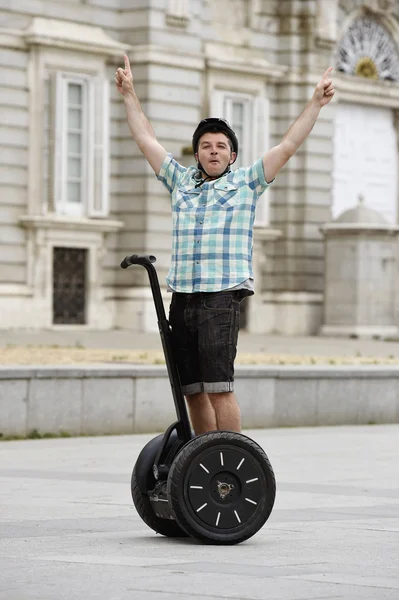 Young happy tourist man wearing safety helmet headgear riding city tour segway driving happy — Stock Fotó