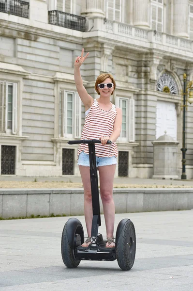Tânără atractivă femeie turistică în pantaloni scurți tur al orașului pe segmentul electric fericit în Spania — Fotografie, imagine de stoc
