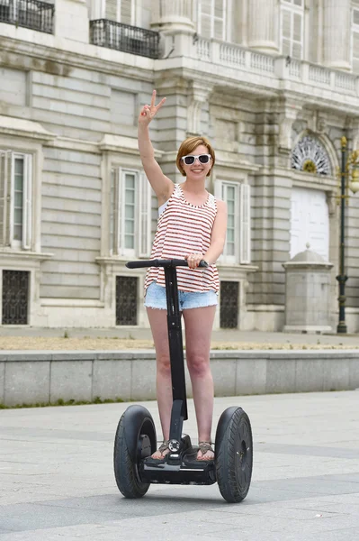 Junge attraktive Touristin in kurzen Hosen fährt glücklich elektrisches Segway in Spanien — Stockfoto