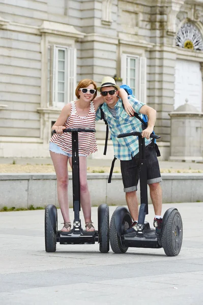 Young happy tourist couple riding segway enjoying city tour in Madrid palace in Spain having fun driving together — Zdjęcie stockowe