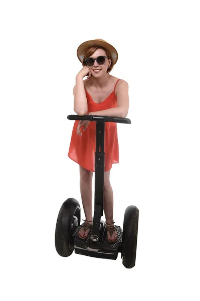 Young attractive tourist woman in chic summer dress smiling happy riding electrical segway — ストック写真
