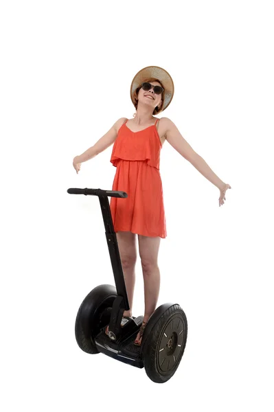 Young attractive tourist woman in chic summer dress smiling happy riding electrical segway — Zdjęcie stockowe