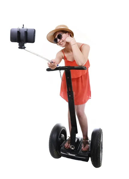 Young chic tourist woman taking selfie photo with mobile phone while riding on segway — Zdjęcie stockowe