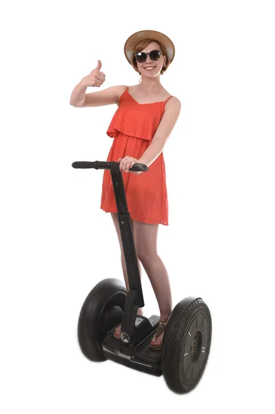 Young attractive tourist woman in chic summer dress smiling happy riding electrical segway — Zdjęcie stockowe