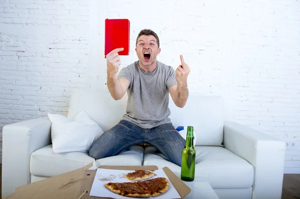 Young man alone holding notepad showing it as referee red card in angry face giving the finger — Stockfoto