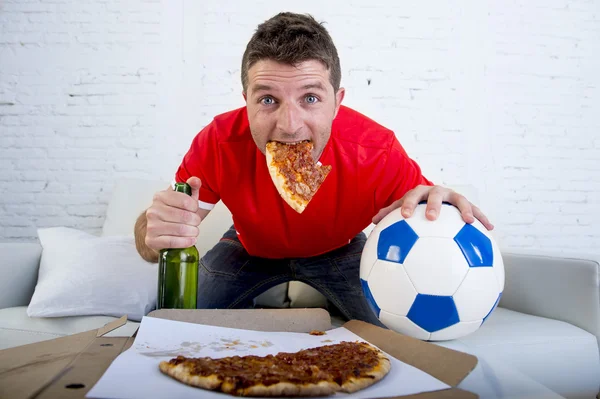 Junger Mann schaut Fußballspiel im Fernsehen und sieht aufgeregt und ängstlich auf Sofa sitzend — Stockfoto