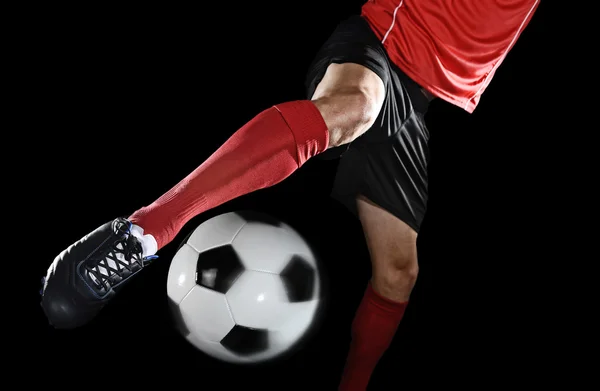 Chiudere le gambe e scarpe da calcio del giocatore di calcio in azione calci palla isolato su sfondo nero — Foto Stock