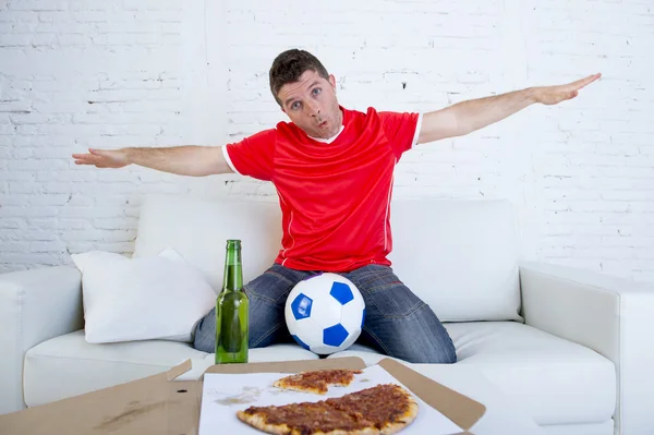Jeune fan de football homme regarder le match à la télévision dans le maillot de l'équipe célébrant but fou heureux sur le canapé — Photo