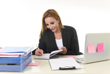 dizüstü bilgisayar ofis masasında çalışan iş kadını not defterine yazma notları alarak