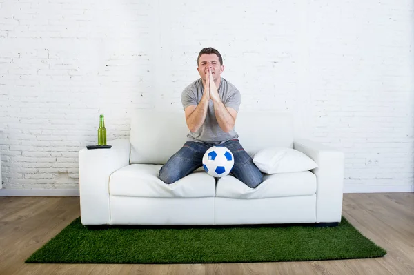football fan watching television soccer match suffering stress praying god