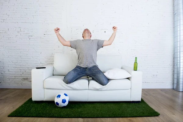 Fã de futebol assistindo jogo de tv no sofá com grama gramado tapete celebrando objetivo — Fotografia de Stock