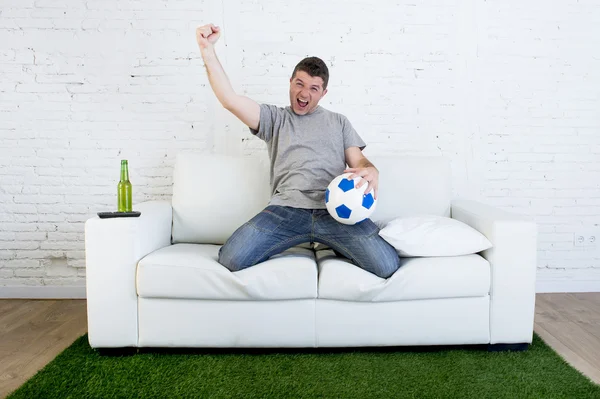 Ventilador de fútbol viendo partido de televisión en sofá con alfombra de césped c — Foto de Stock