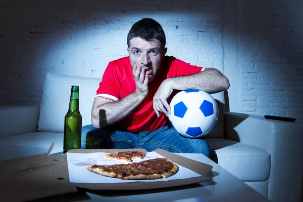 Jovem fã homem assistindo jogo de futebol na tv em equipe jersey sofrendo nervoso e estresse — Fotografia de Stock