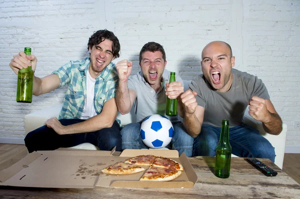 Друзья фанатичные футбольные болельщики смотрят игру по телевизору празднование цели кричать сумасшедшие счастливы — стоковое фото