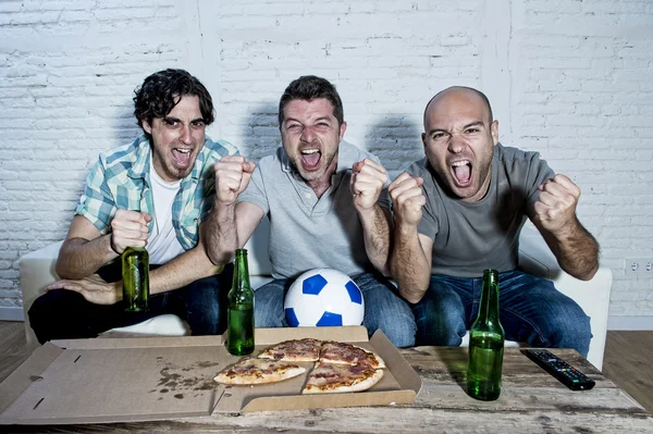 Друзья фанатичные футбольные болельщики смотрят игру по телевизору празднование цели кричать сумасшедшие счастливы — стоковое фото