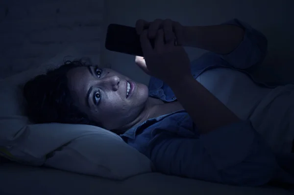 Молодая красивая женщина лежит на домашнем диване с помощью мобильного телефона интернет-зависимость концепции — стоковое фото