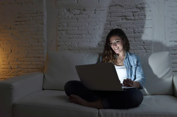 Séduisante femme détendue à la maison assise heureuse sur le canapé en utilisant un ordinateur portable la nuit — Photo