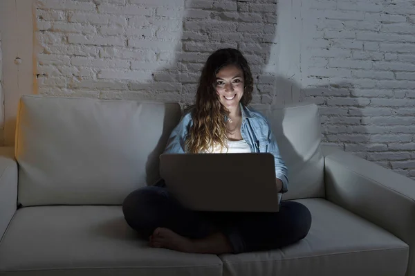 Nyugodt vonzó nő otthon ül boldog használ laptop, sötét este kanapén — Stock Fotó